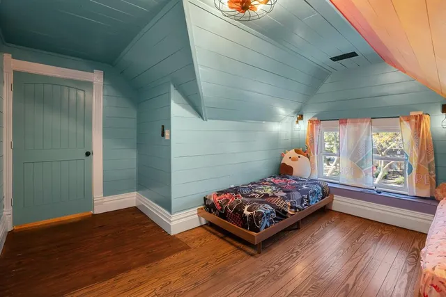 a bedroom with a bed and wooden floor