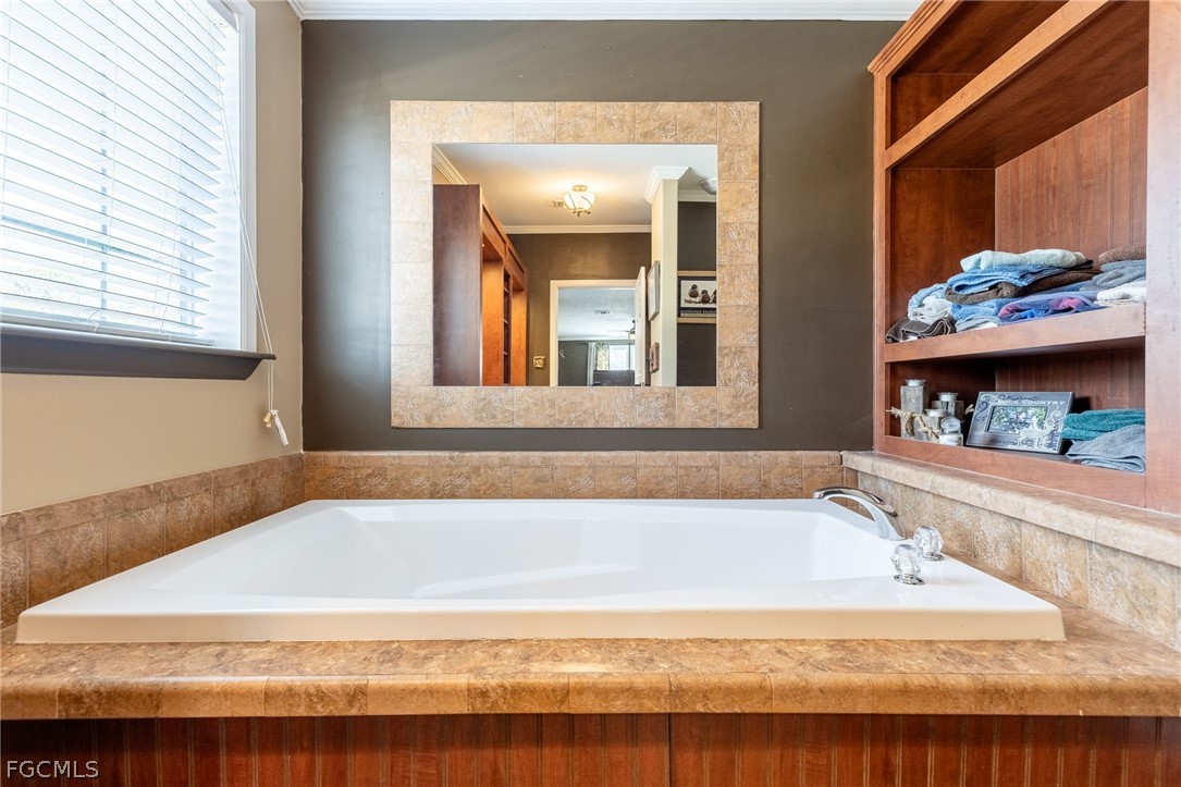2032 Ortona Locks Road Moore Haven, FL 33471 - Photo 25 of 48 a bathroom with bathtub and a window