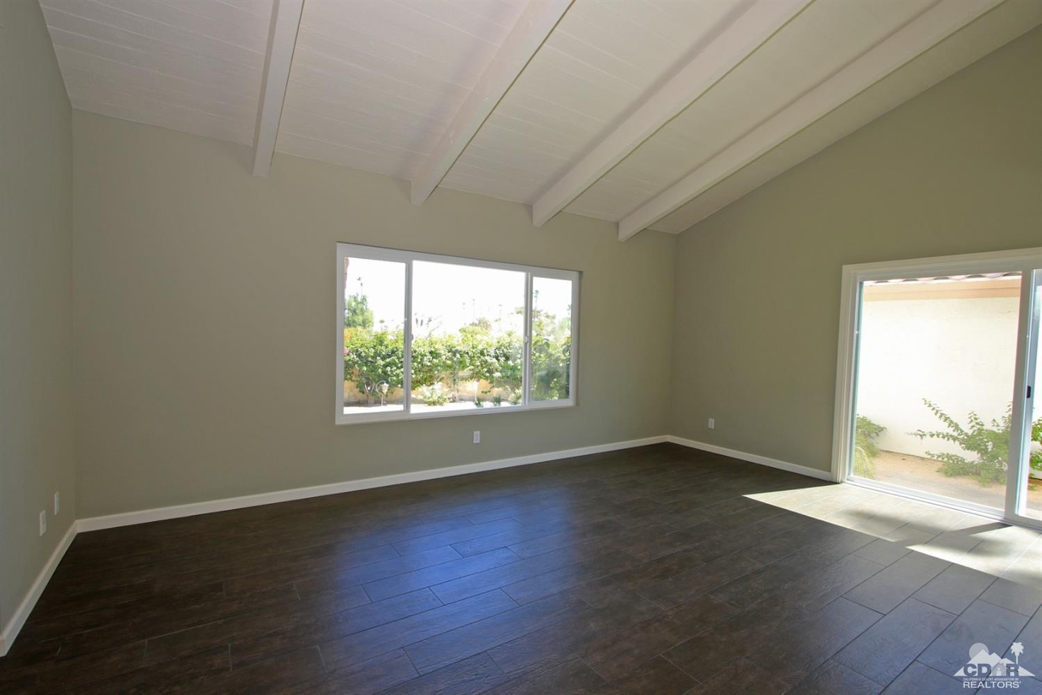 73733 Haystack Road Palm Desert, CA 92260 - Photo 16 of 36 an empty room with wooden floor and windows