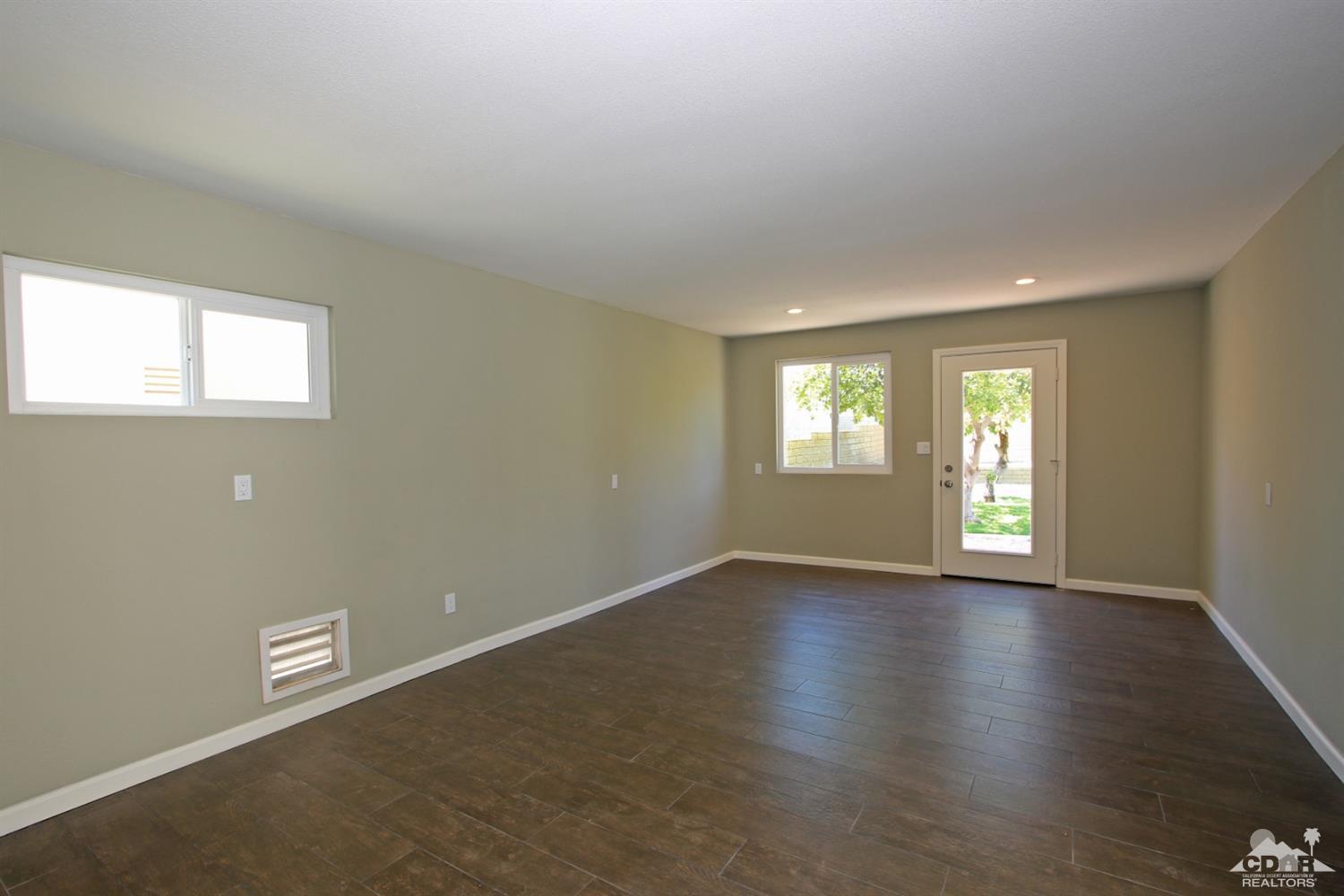 73733 Haystack Road Palm Desert, CA 92260 - Photo 33 of 36 an empty room with wooden floor and windows