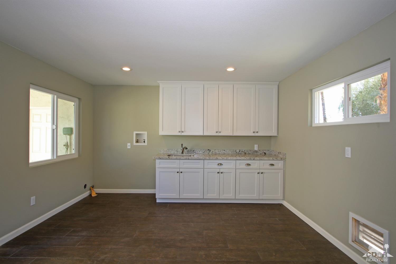 73733 Haystack Road Palm Desert, CA 92260 - Photo 35 of 36 a kitchen with granite countertop white cabinets and window