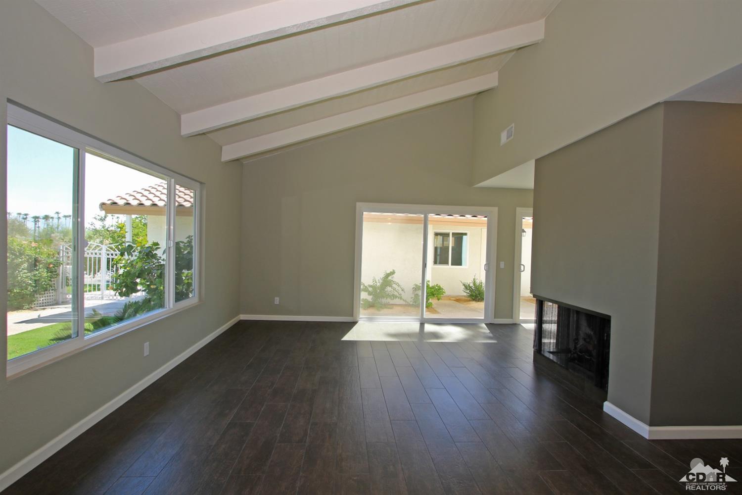 73733 Haystack Road Palm Desert, CA 92260 - Photo 6 of 36 a view of an empty room with wooden floor and a window