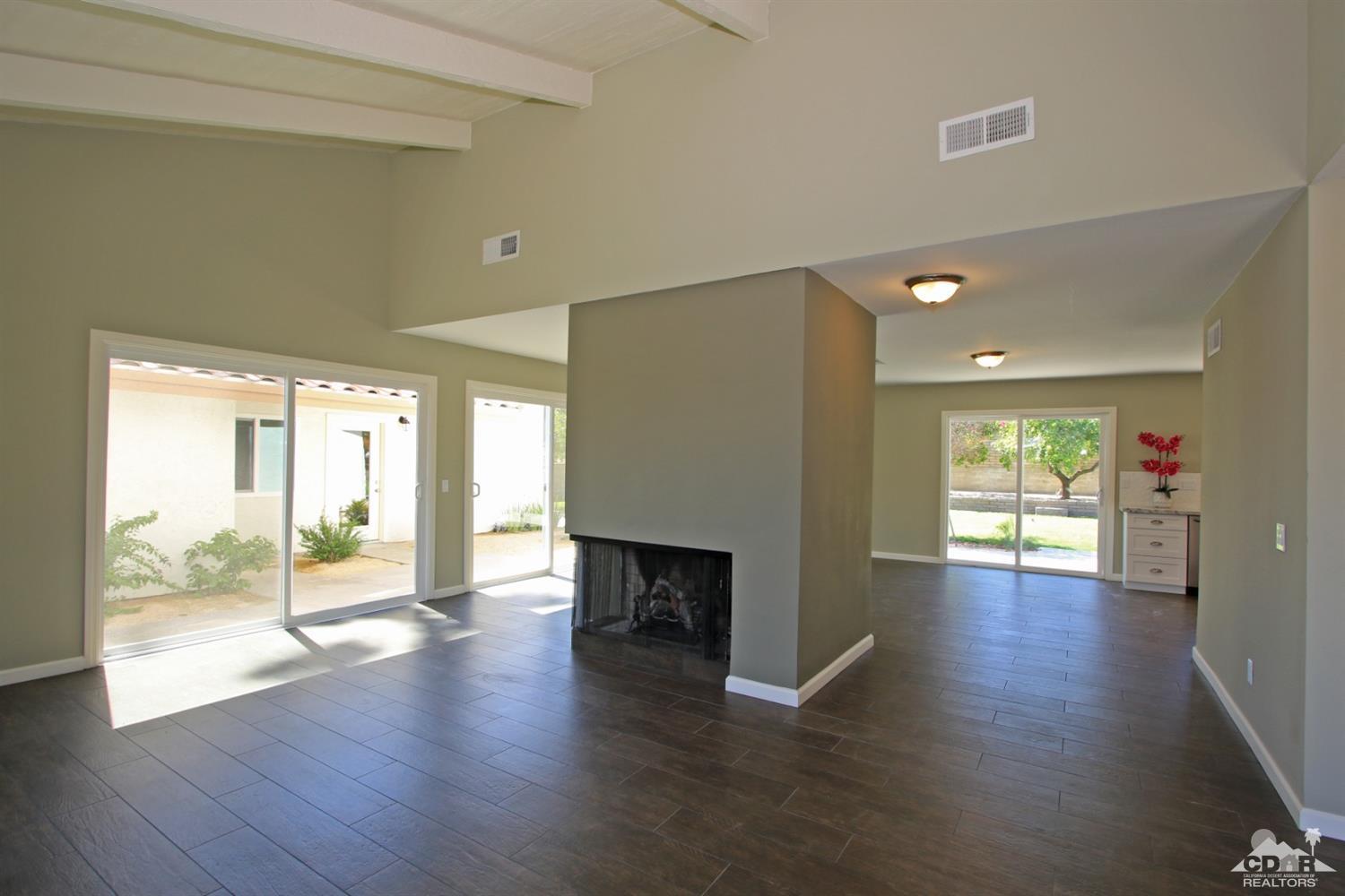 73733 Haystack Road Palm Desert, CA 92260 - Photo 7 of 36 a view of a big room with wooden floor and a fireplace