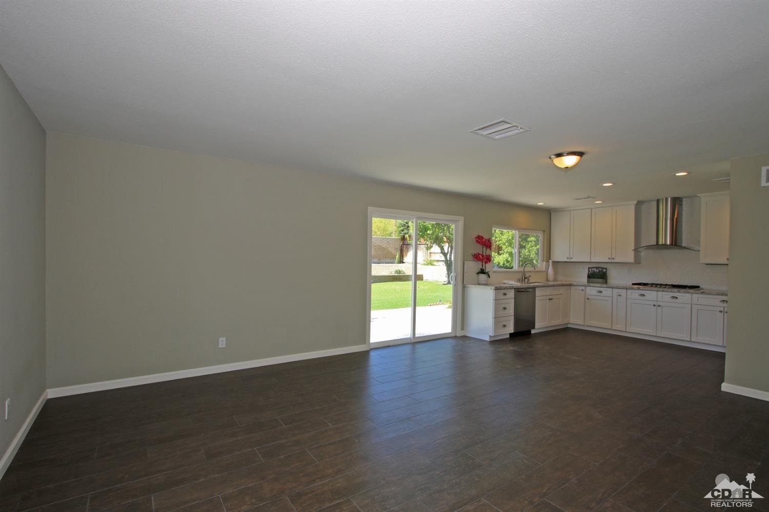 73733 Haystack Road Palm Desert, CA 92260 - Photo 9 of 36 a view of an empty room with a window and wooden floor