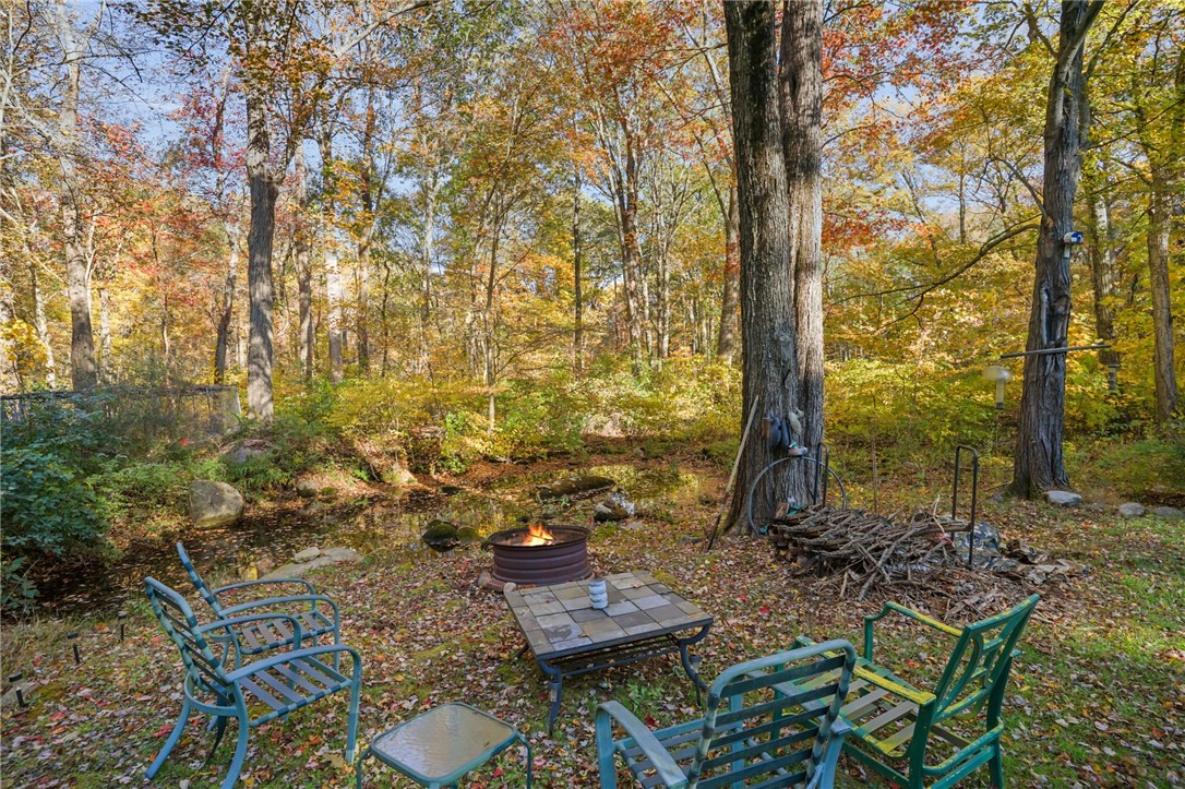 550 Twin Brook Lane Coventry, RI 02816 - Photo 29 of 41 View out back with a firepit and small pond