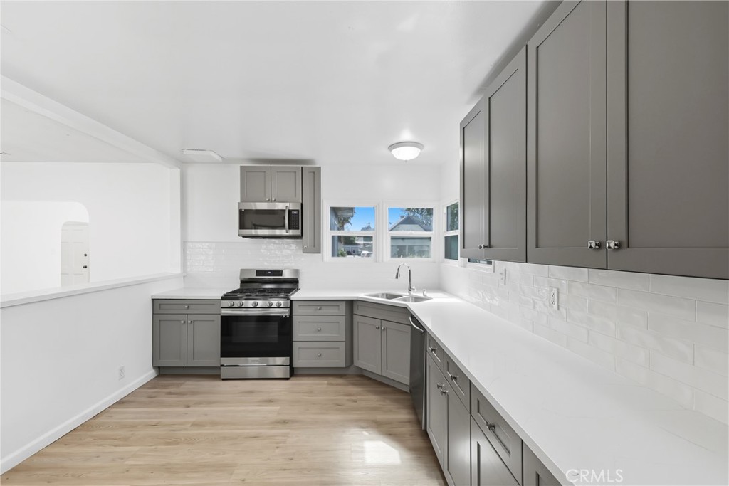 3841 Locust Street Riverside, CA 92501 - Photo 25 of 57 a kitchen with stainless steel appliances granite countertop a sink stove and refrigerator