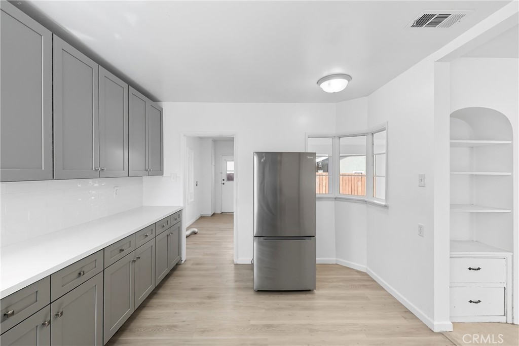 3841 Locust Street Riverside, CA 92501 - Photo 26 of 57 a view of a kitchen with a refrigerator cabinets and a wooden floor