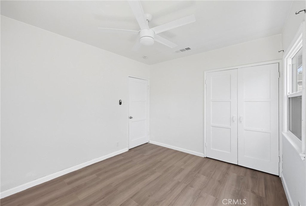 3841 Locust Street Riverside, CA 92501 - Photo 34 of 57 an empty room with wooden floor and a ceiling fan