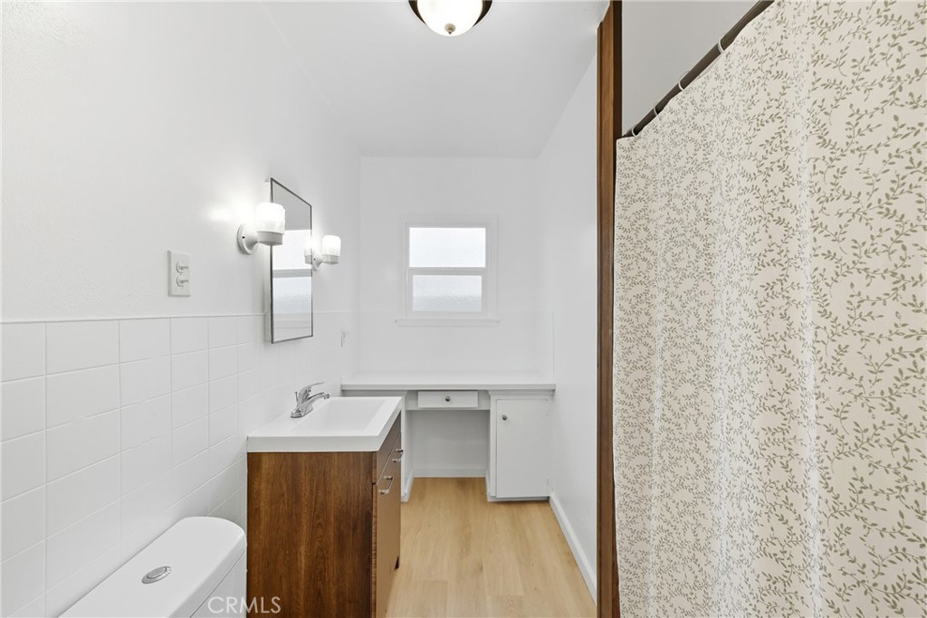 3841 Locust Street Riverside, CA 92501 - Photo 35 of 57 a bathroom with a sink a toilet and a mirror