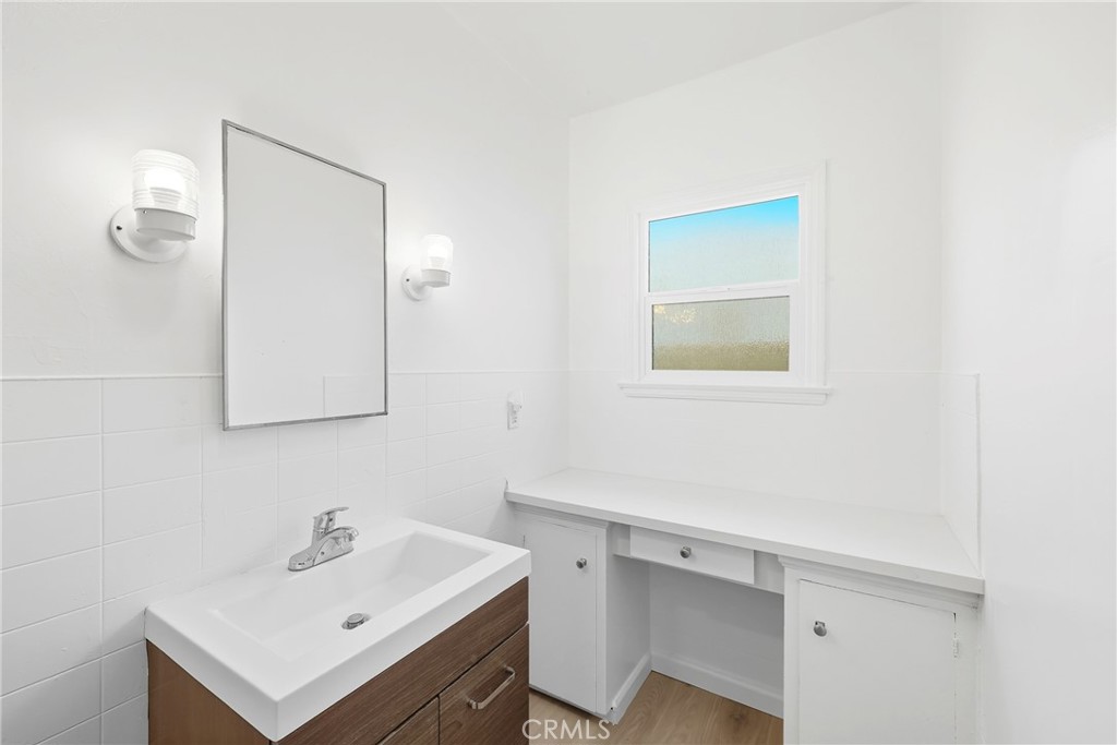 3841 Locust Street Riverside, CA 92501 - Photo 36 of 57 a bathroom with a sink a mirror and vanity