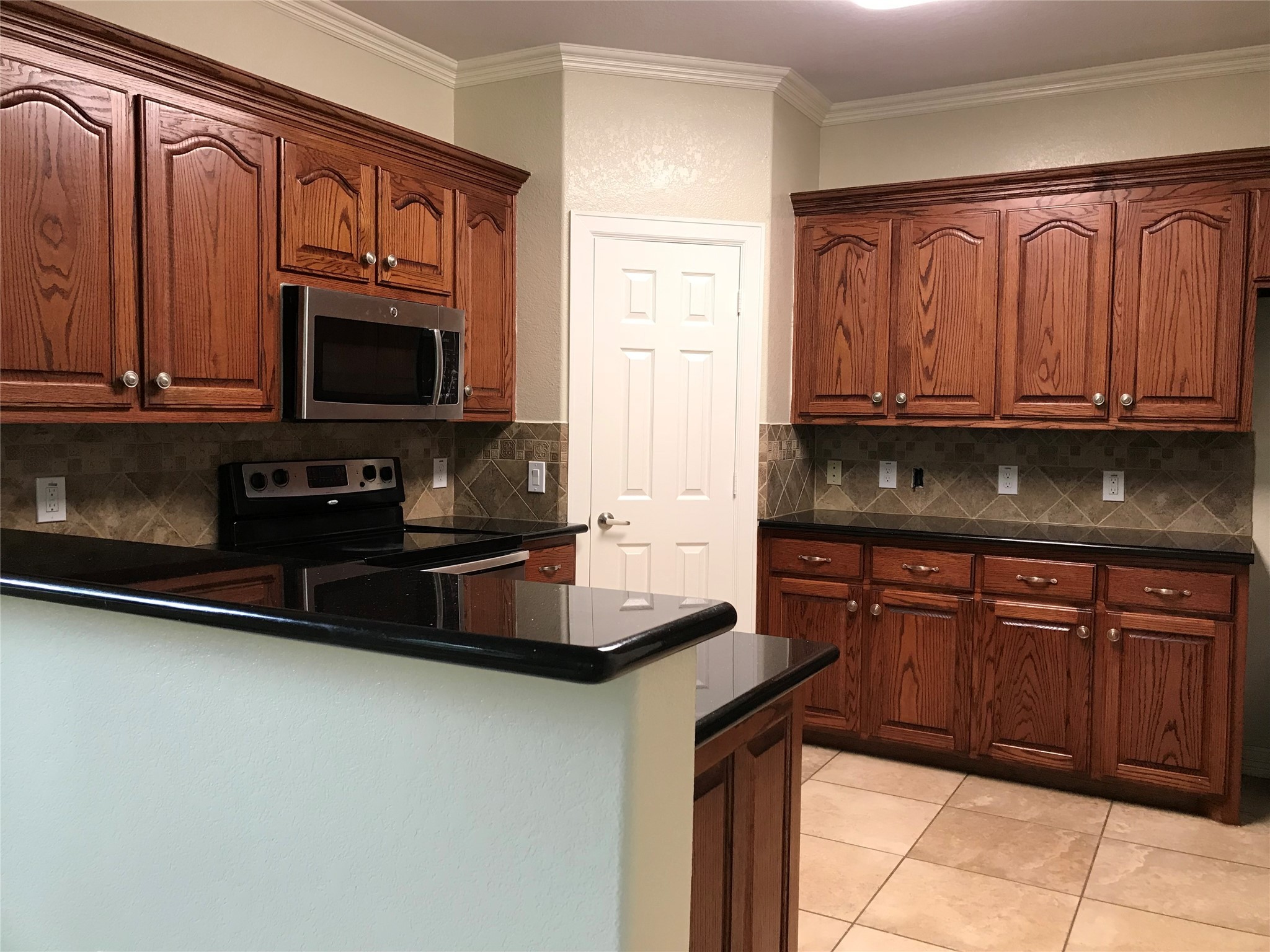 4925 Talina Way Houston, TX 77041 - Photo 9 of 12 a kitchen with granite countertop a stove microwave and sink with granite countertops