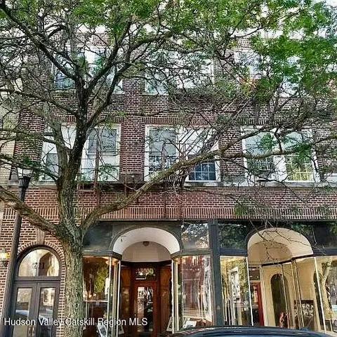 a front view of house with large trees