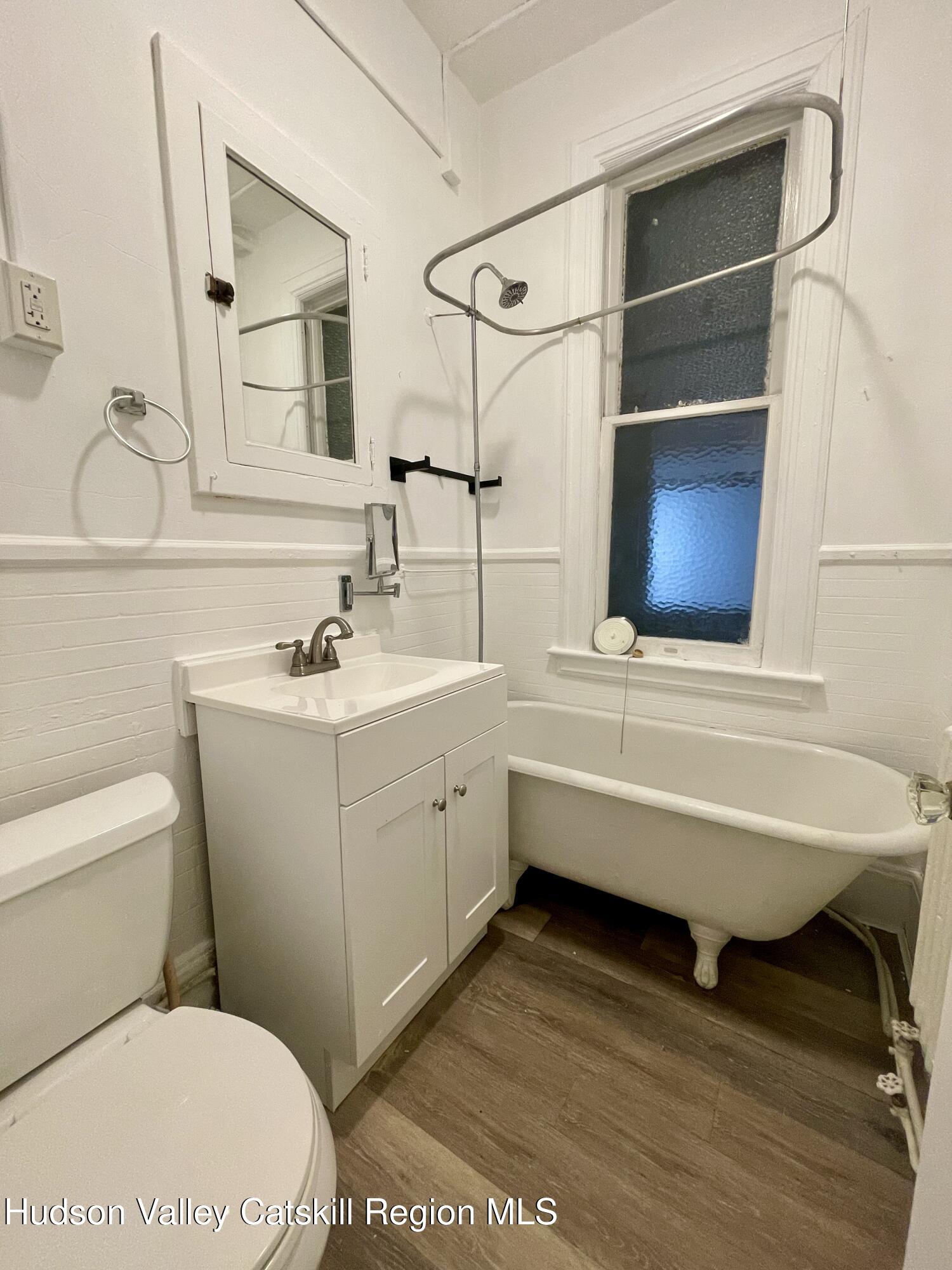 711 Warren Street, Unit 4 Hudson, NY 12534 - Photo 5 of 14 a bathroom with a sink toilet vanity and mirror