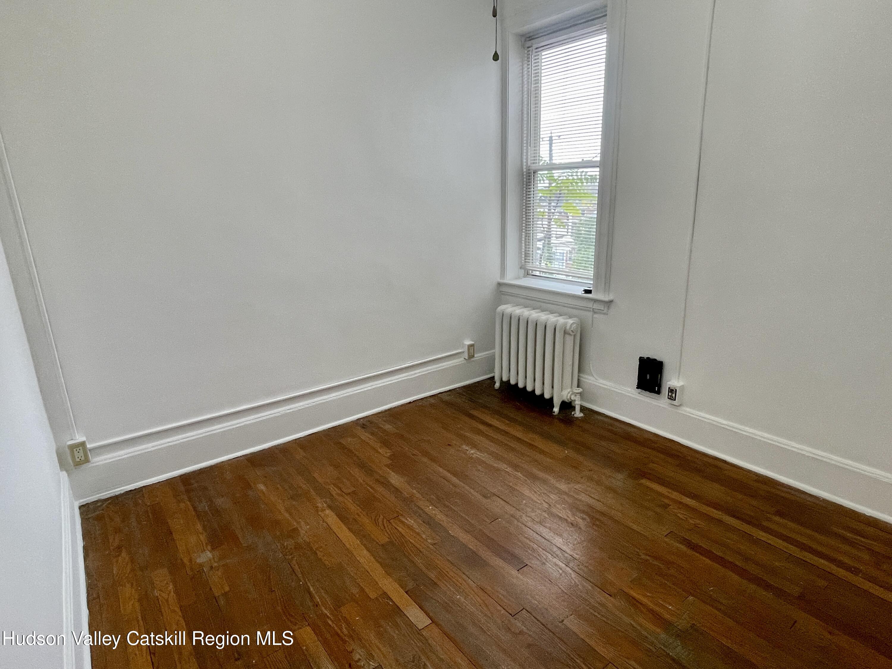 711 Warren Street, Unit 4 Hudson, NY 12534 - Photo 8 of 14 a view of an empty room with wooden floor and a window