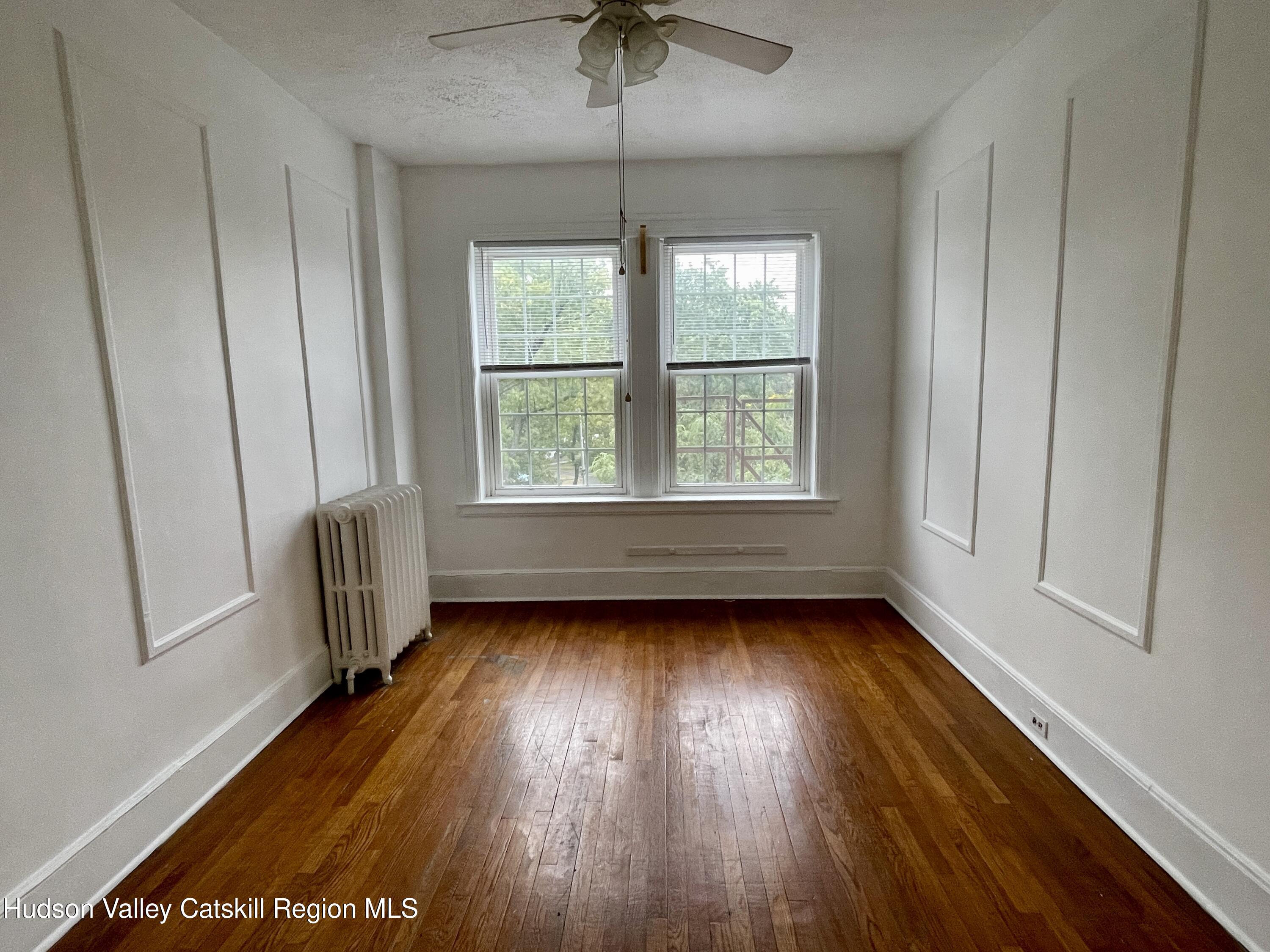 711 Warren Street, Unit 4 Hudson, NY 12534 - Photo 10 of 14 a view of an empty room with a window and wooden floor
