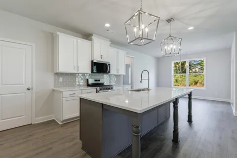 a kitchen with kitchen island granite countertop stainless steel appliances a sink stove and microwave