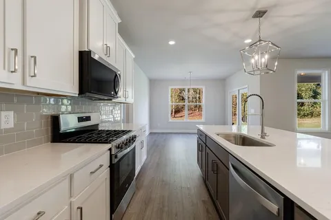 a kitchen with stainless steel appliances granite countertop a sink stove a microwave and cabinets