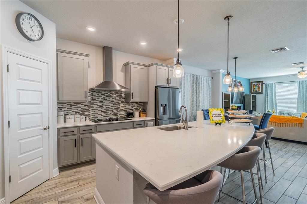 5538 Spanish Moss Cove Bradenton, FL 34203 - Photo 15 of 31 a kitchen with stainless steel appliances granite countertop a stove a refrigerator a oven a dining table with chairs and white cabinets