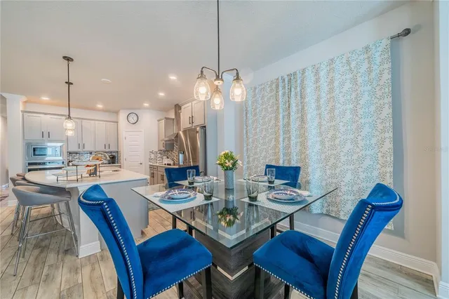 a view of a dining room with furniture a rug and wooden floor