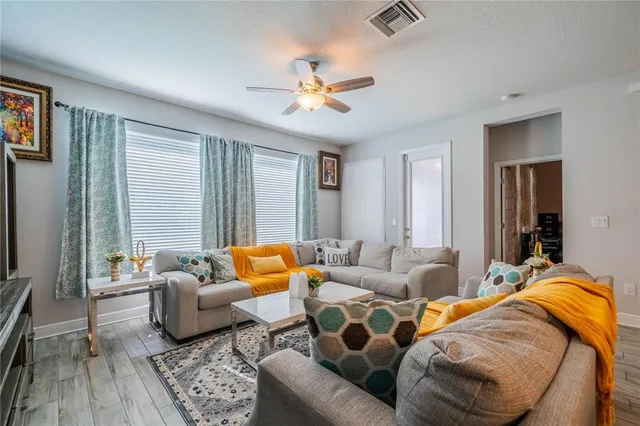 a living room with furniture kitchen view and a flat screen tv