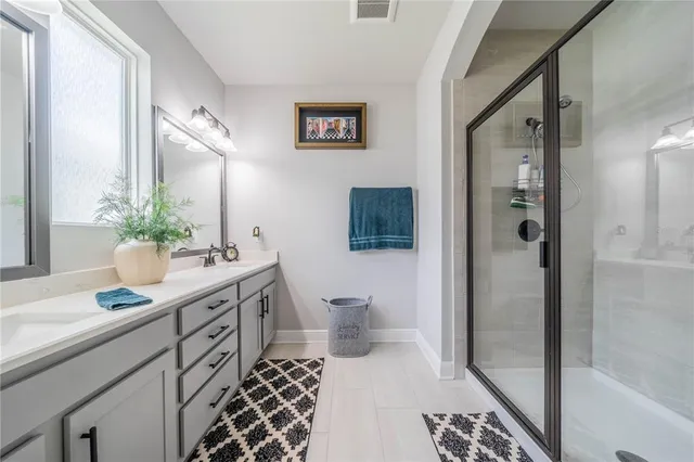 a spacious bathroom with a double vanity sink a mirror and a toilet