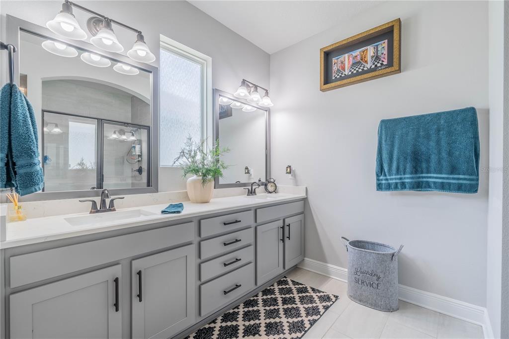 5538 Spanish Moss Cove Bradenton, FL 34203 - Photo 25 of 31 a spacious bathroom with a double vanity sink a mirror and a toilet