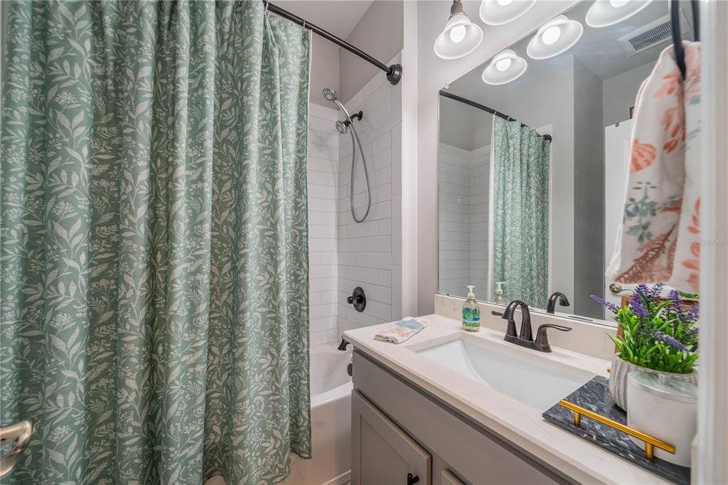 5538 Spanish Moss Cove Bradenton, FL 34203 - Photo 8 of 31 a bathroom with a sink a mirror and a shower curtain