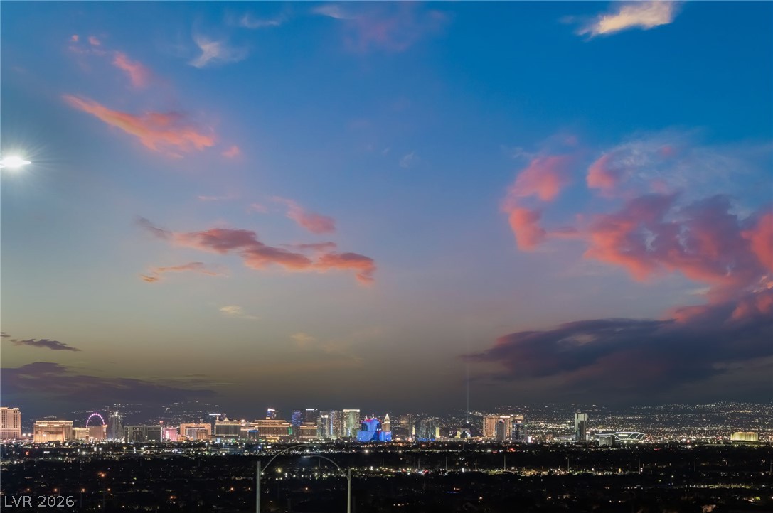 6432 Spring Jog Street Las Vegas, NV 89166 - Photo 60 of 61 Sweeping city lights and a picturesque sky create an enchanting evening panorama.