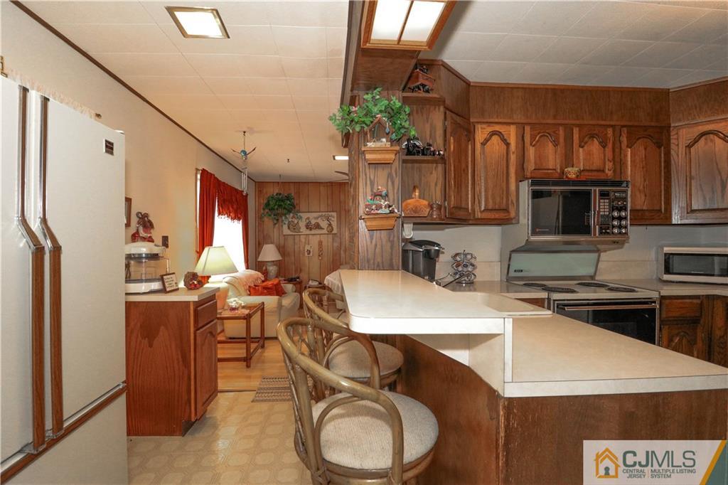 38 Gurley Road Edison, NJ 08817 - Photo 14 of 25 a kitchen with stainless steel appliances granite countertop a sink a stove a refrigerator cabinets and chairs
