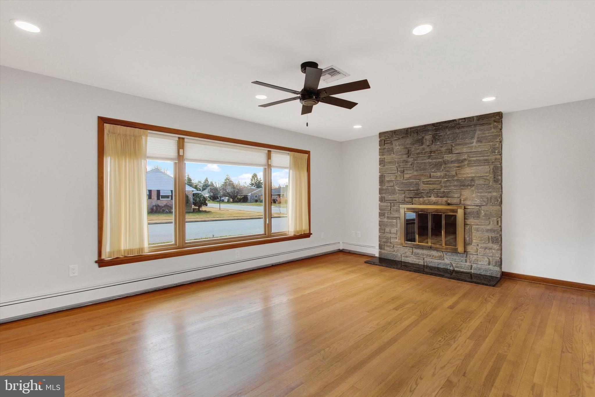 200 Sunset Avenue Hanover, PA 17331 - Photo 5 of 28 an empty room with wooden floor fireplace and windows