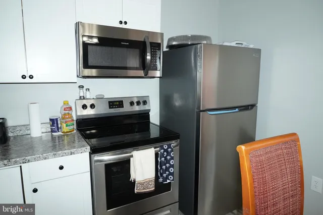 a kitchen with stainless steel appliances granite countertop a refrigerator stove and microwave