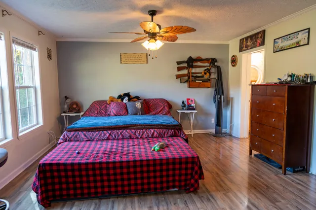 a bedroom with a bed and wooden floor