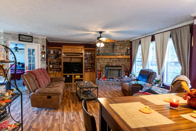a living room with furniture fireplace and a large window