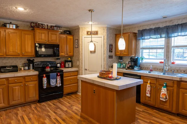 a kitchen with stainless steel appliances granite countertop a stove a sink dishwasher and a microwave oven with cabinets