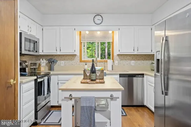 a kitchen with a refrigerator sink and cabinets