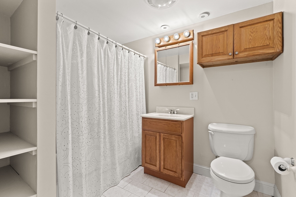 6 Shetland Road Marblehead, MA 01945 - Photo 31 of 39 a bathroom with a toilet a sink and a shower curtain
