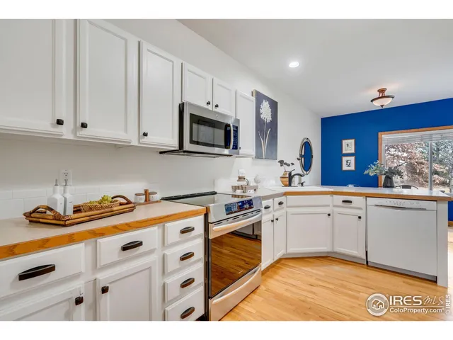 a kitchen with granite countertop a sink stainless steel appliances and cabinets