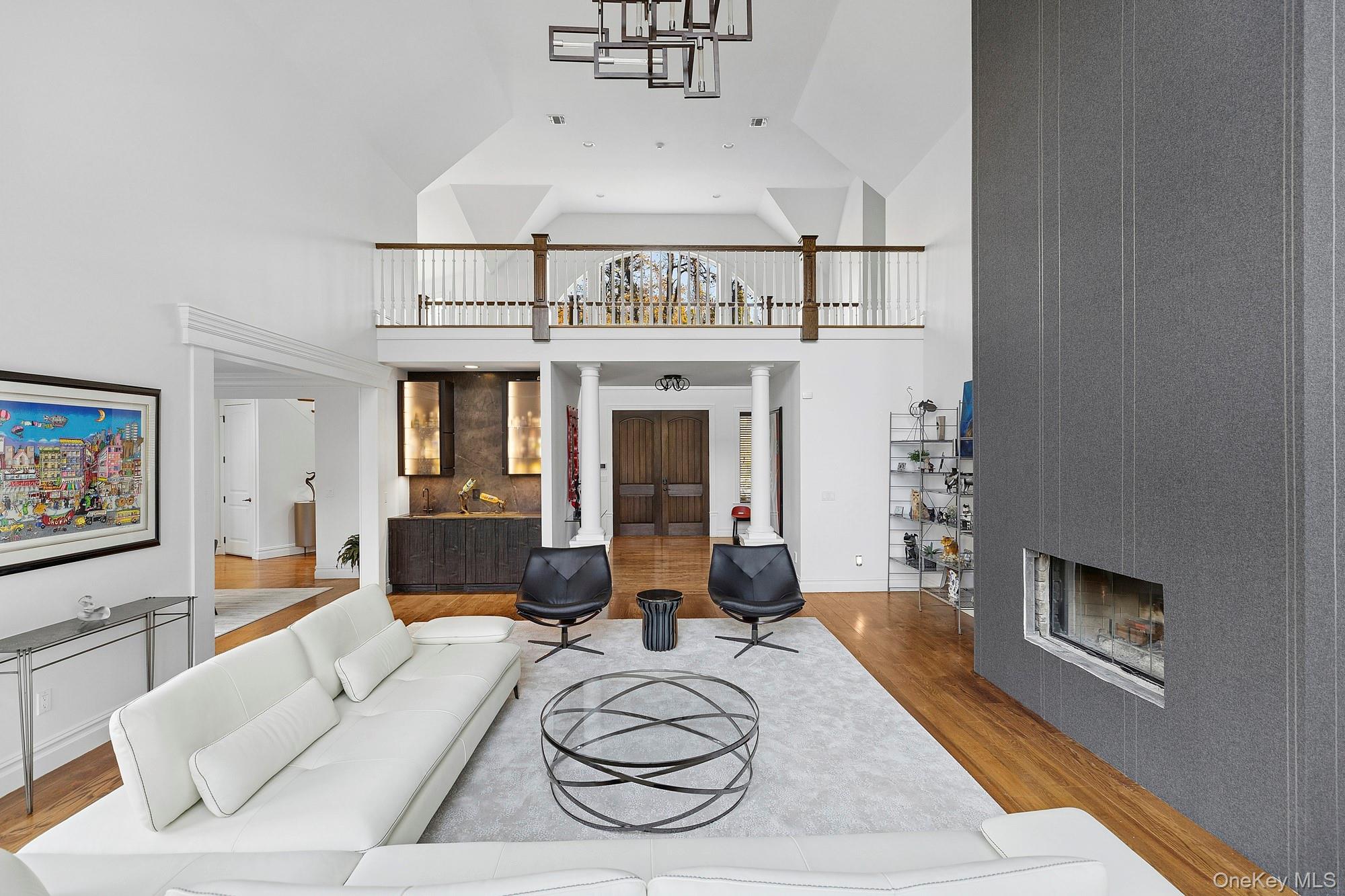 144 Round Swamp Road West Hills, NY 11743 - Photo 14 of 39 Living area with wood finished floors, a large fireplace, and a towering ceiling