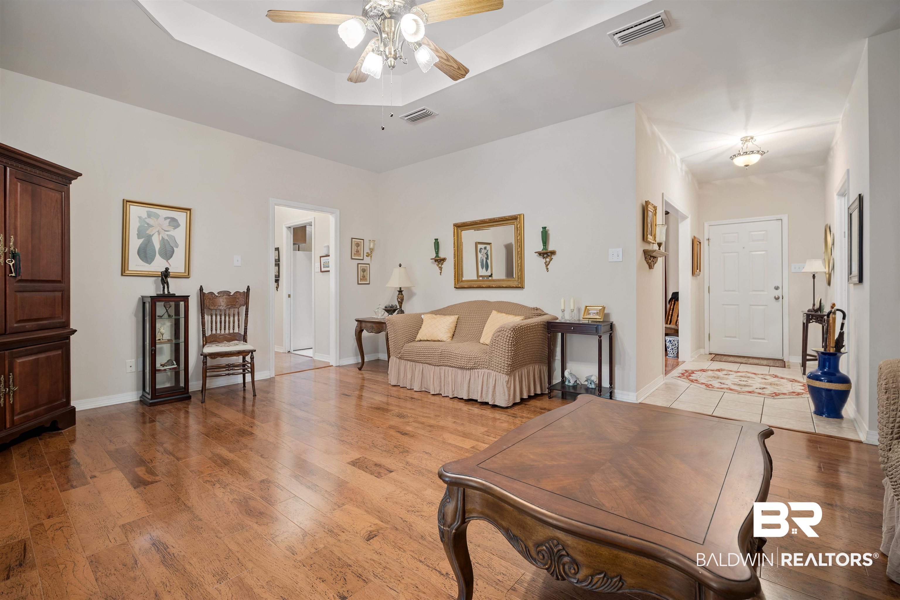 7419 Pake Road Saraland, AL 36571 - Photo 6 of 27 Living room with a tray ceiling, ceiling fan, and light hardwood / wood-style floors