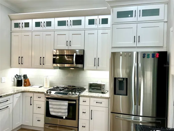 a kitchen with stainless steel appliances granite countertop a refrigerator stove and sink