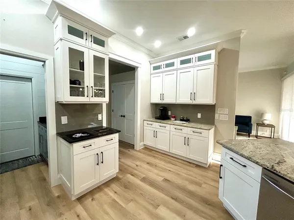 a kitchen with granite countertop a stove top oven sink and cabinets