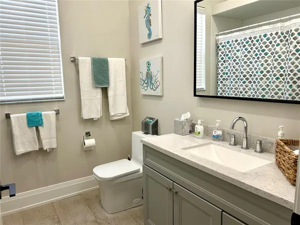 a bathroom with a granite countertop toilet sink and mirror
