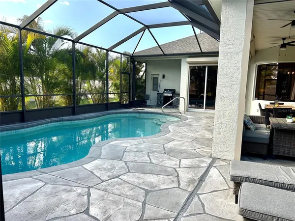 a view of a patio with table and chairs a barbeque with floor to ceiling windows