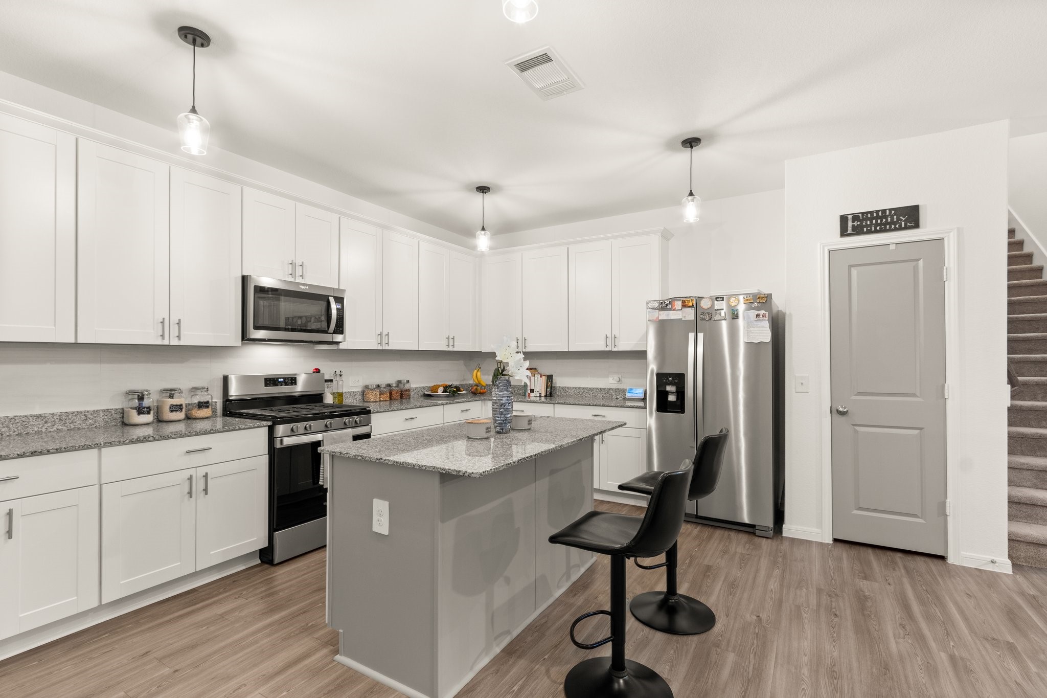 5834 Finely Run St Spring Spring, TX 77373 - Photo 16 of 50 a kitchen with stainless steel appliances granite countertop a refrigerator a stove a sink dishwasher and white cabinets with wooden floor