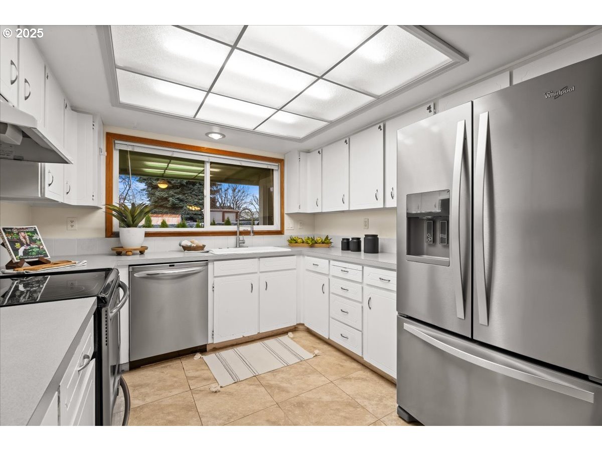 253 South Tarrybrook Circle Cornelius, OR 97113 - Photo 12 of 23 a kitchen with stainless steel appliances granite countertop a stove a sink dishwasher a refrigerator and white cabinets with wooden floor