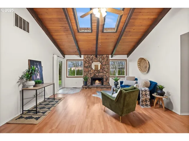 a living room with furniture a fireplace a rug and a large window