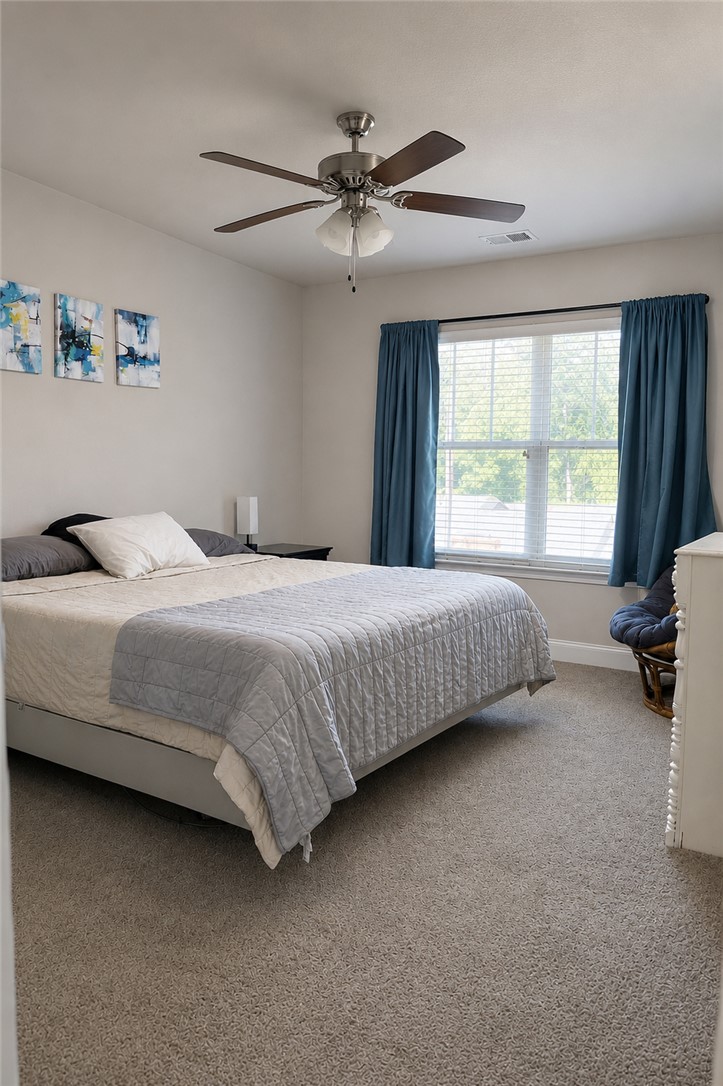 102 Ventura Street Anderson, SC 29621 - Photo 14 of 24 A comfortable bedroom features plush carpeting and a cooling ceiling fan, perfect for restful nights.