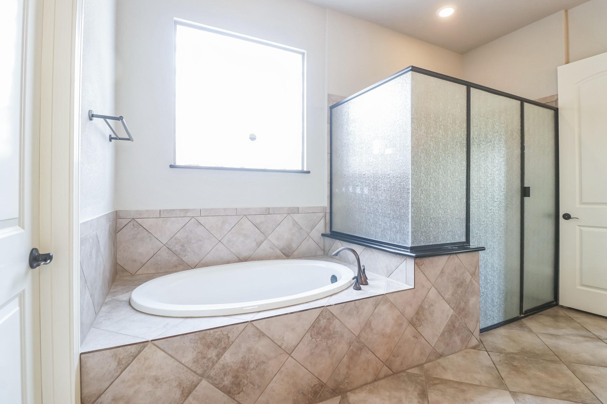 3913 Remington Road Cedar Park, TX 78613 - Photo 18 of 32 Tiled surfaces frame an oval soaking tub and a separate glass-enclosed shower.