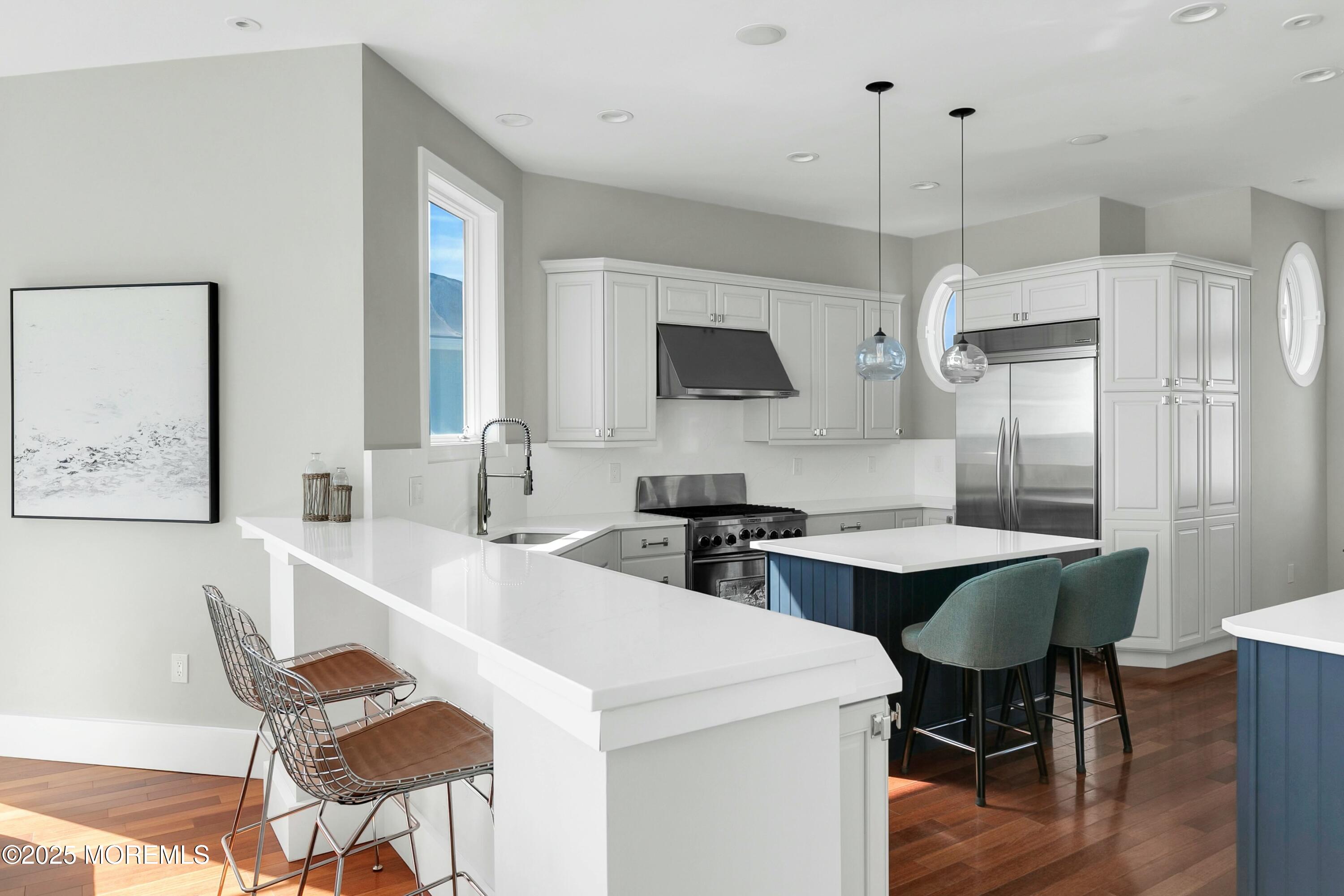 15 Tradewinds Lane Sea Bright, NJ 07760 - Photo 14 of 43 a kitchen with a dining table chairs and a chandelier