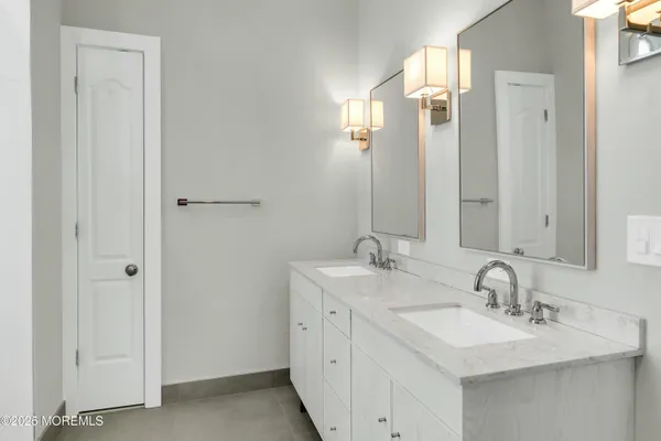 a bathroom with double sink and a mirror